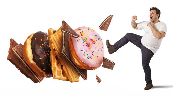 Mann kickt in Donuts, Schokolade und Keckse